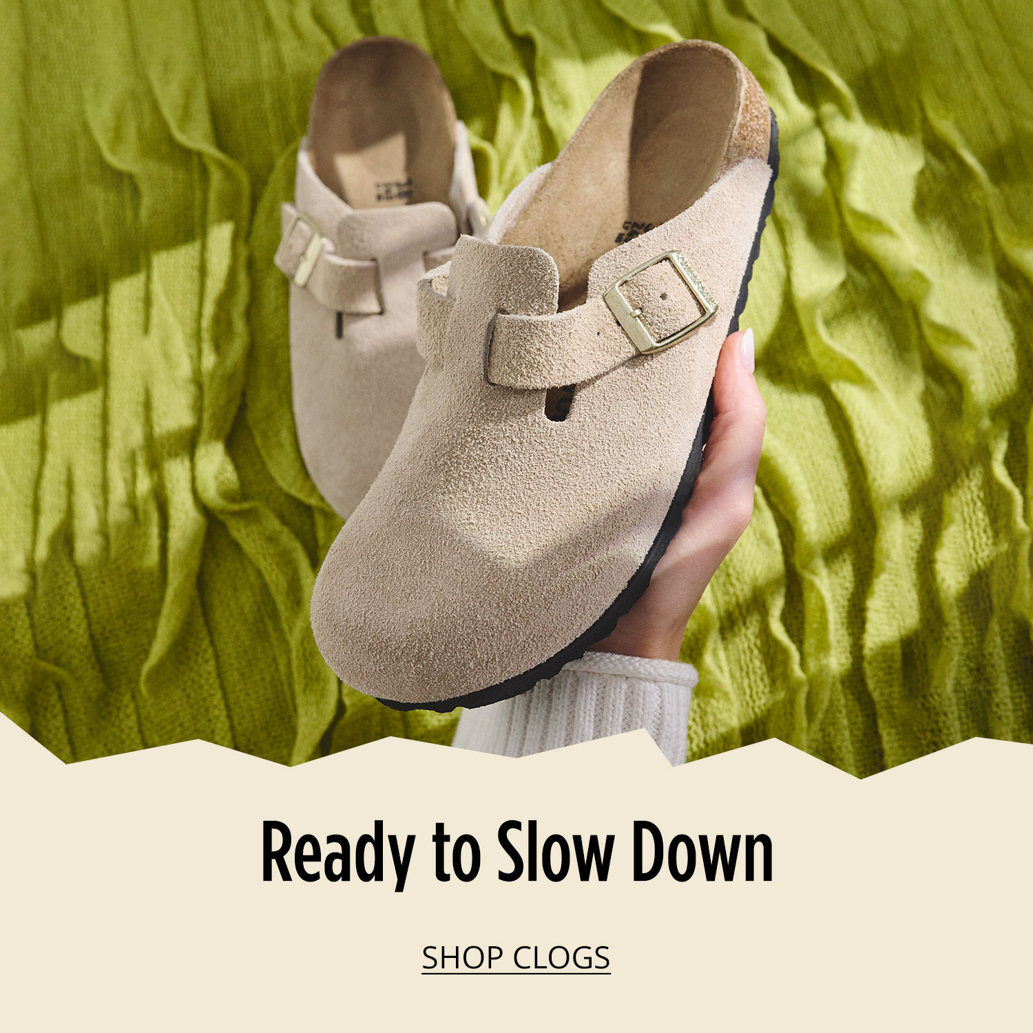 Woman's hand holding one comfortable clog from a pair in focus