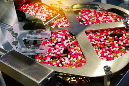 Pill capsules move through the packaging line, ensuring quality and efficiency.