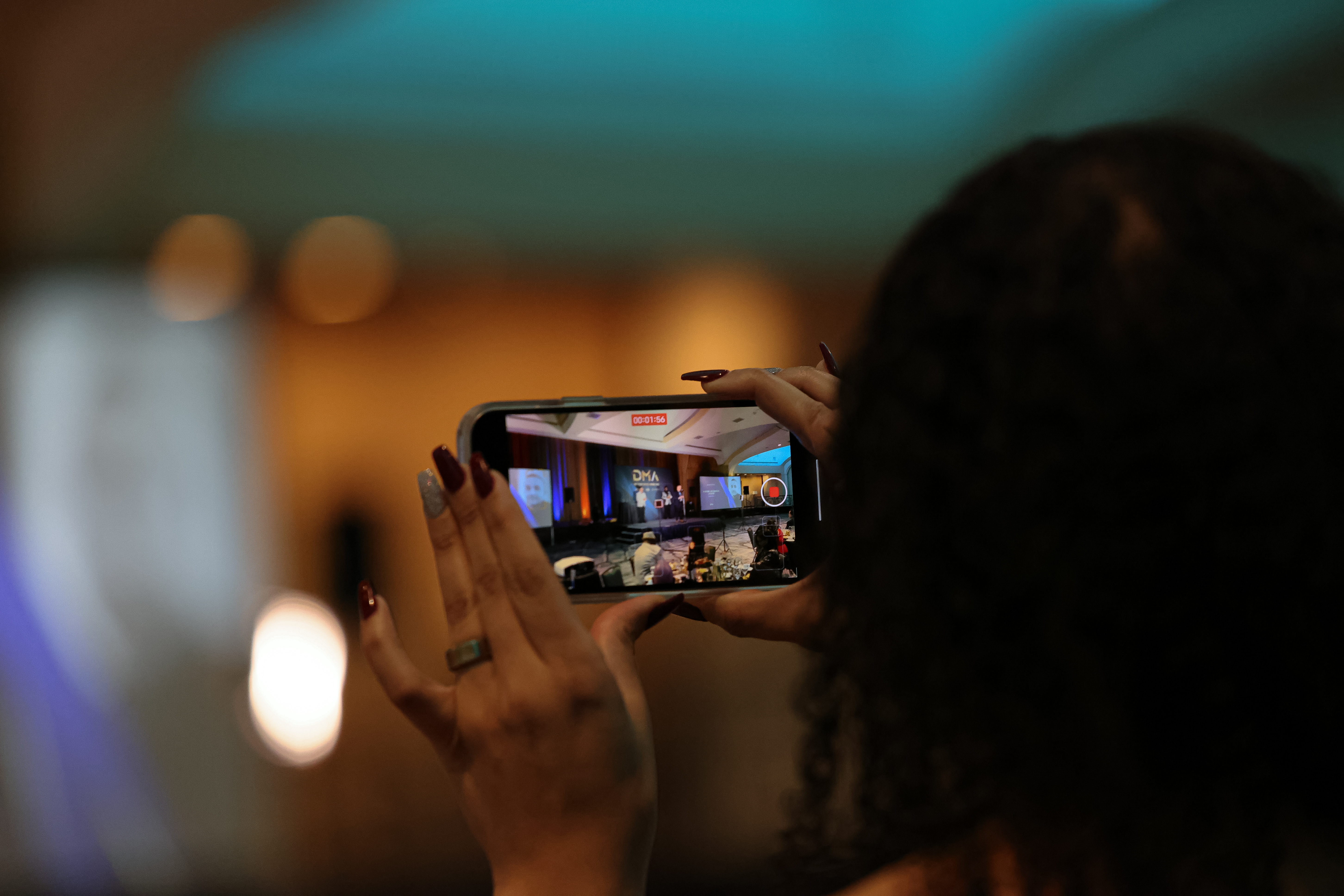 An attendee takes a picture of the award ceremony stage.