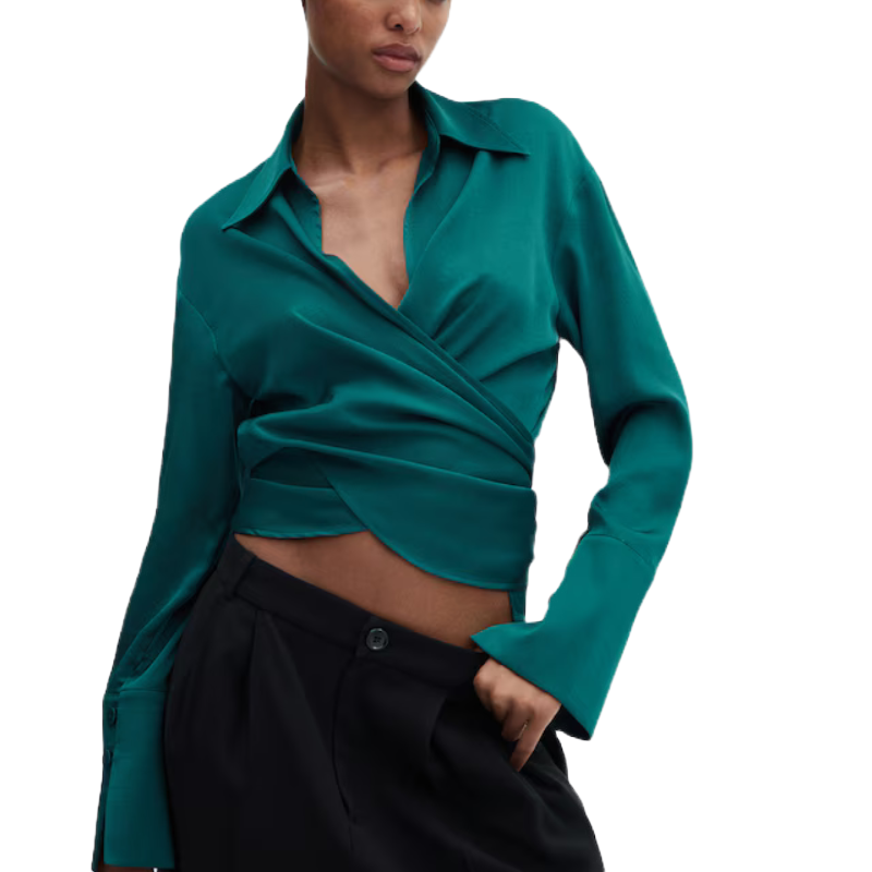 A teal wrap-style blouse with long sleeves and a deep V-neckline, paired with black trousers.