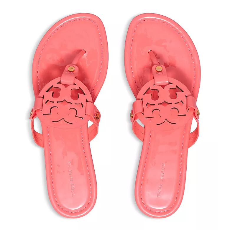 Pink patent leather sandals with a signature cut-out logo design on the strap and a toe loop.