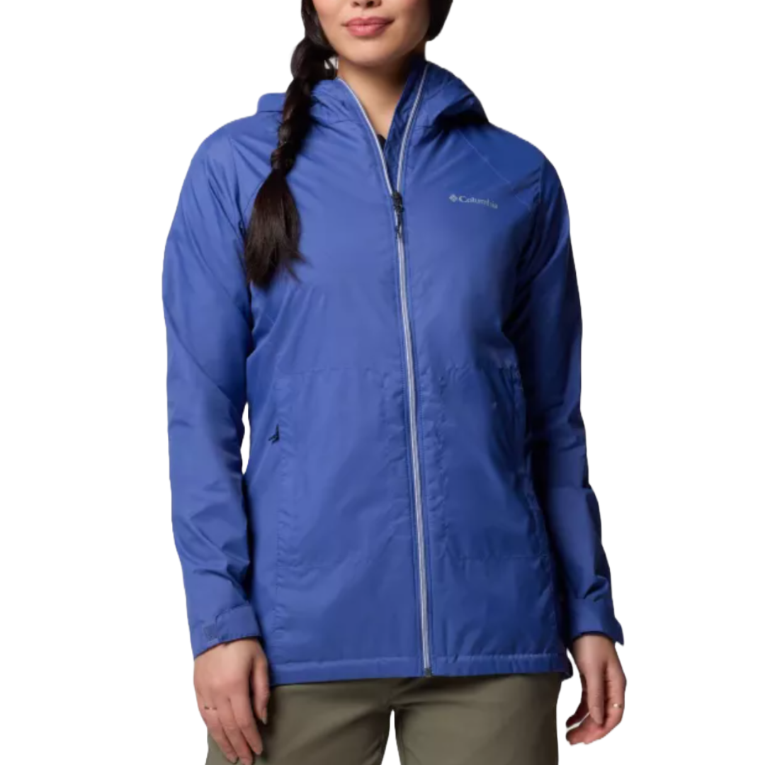 A woman is wearing a blue Columbia jacket with a hood and front zipper, paired with khaki pants.