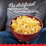 A bowl of popcorn is being held by someone with the text emphasizing no artificial preservatives, flavors, or dyes.