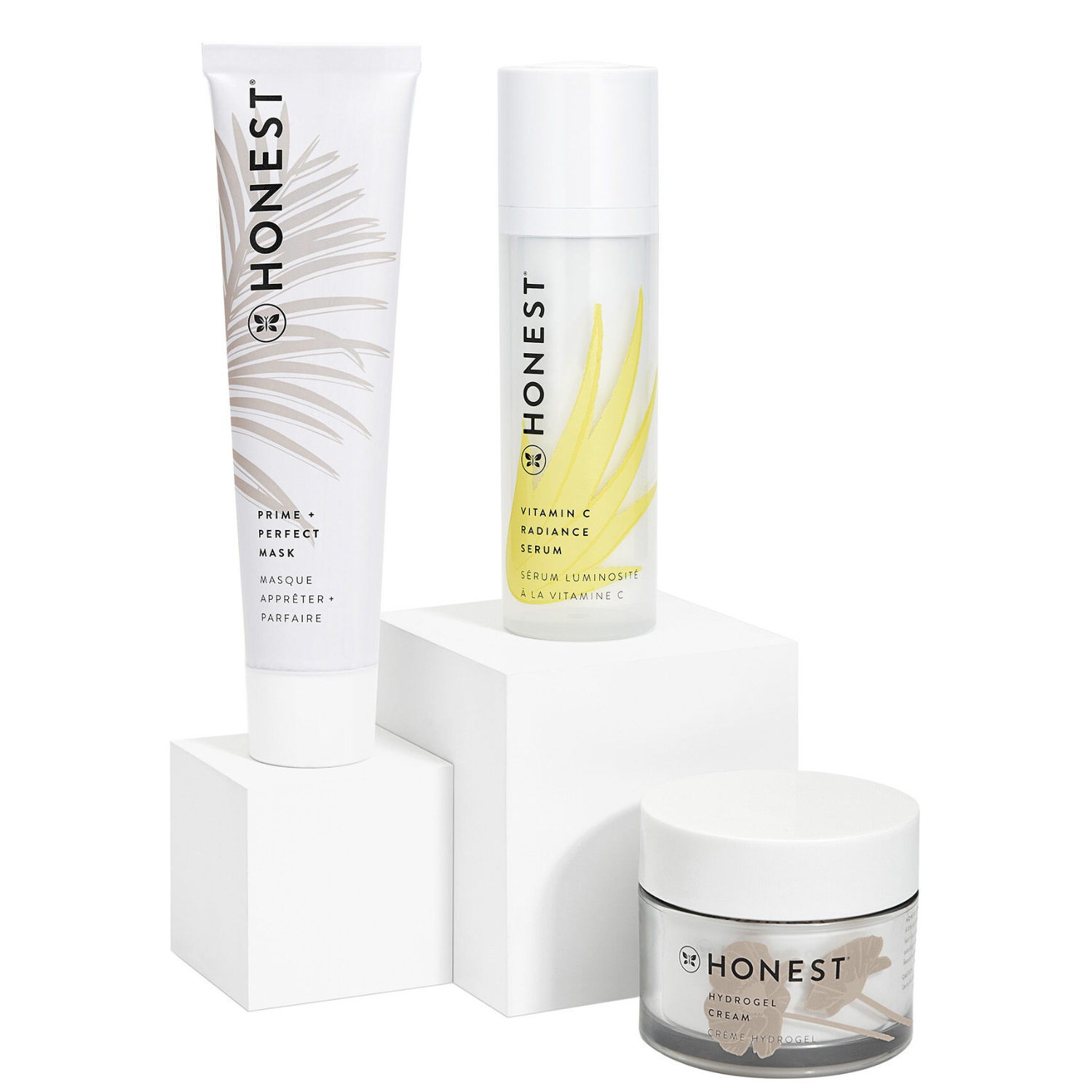Honest Skincare Must-Haves Kit includes Prime + Perfect Mask, Vitamin C Radiance Serum, and Hydrogel Cream. Each is packaged in sleek, minimalist containers, featuring their respective labels and botanical designs.