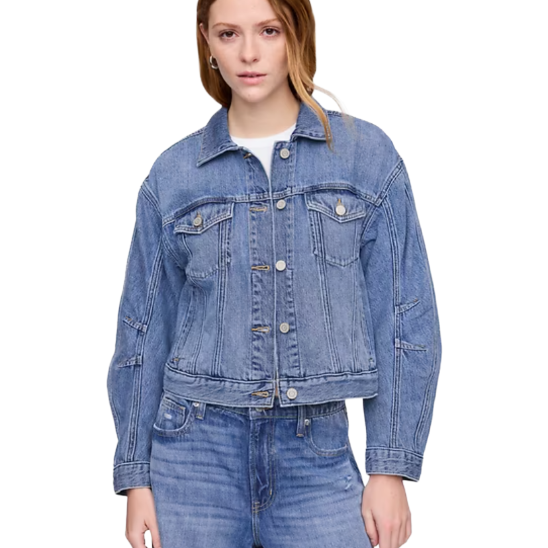 A woman is wearing a blue denim jacket and matching jeans.