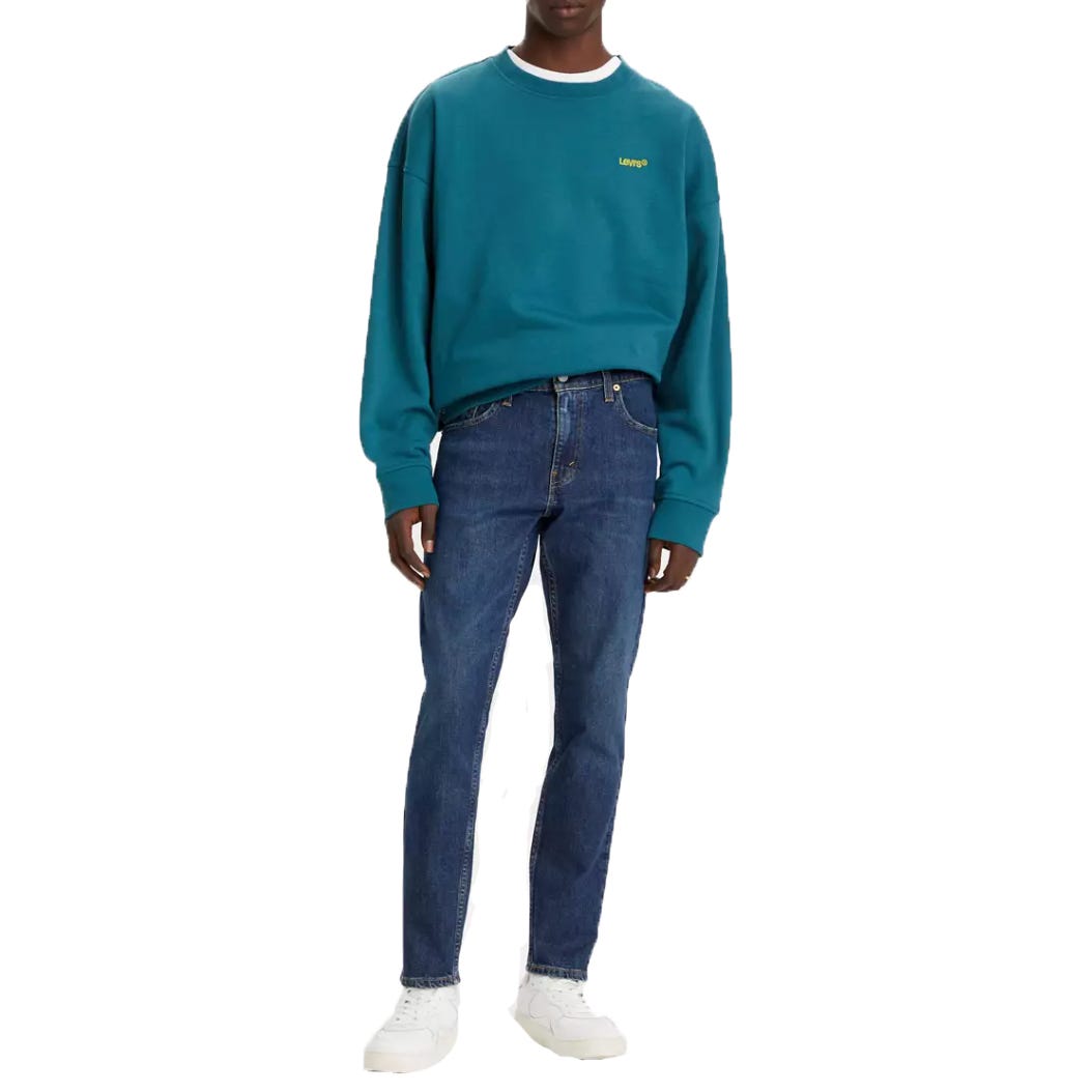 Levi's Slim-Fit Taper Jeans are mid-blue with a classic five-pocket design and a tapered leg. They offer a modern, streamlined look paired well with casual tops and sneakers.