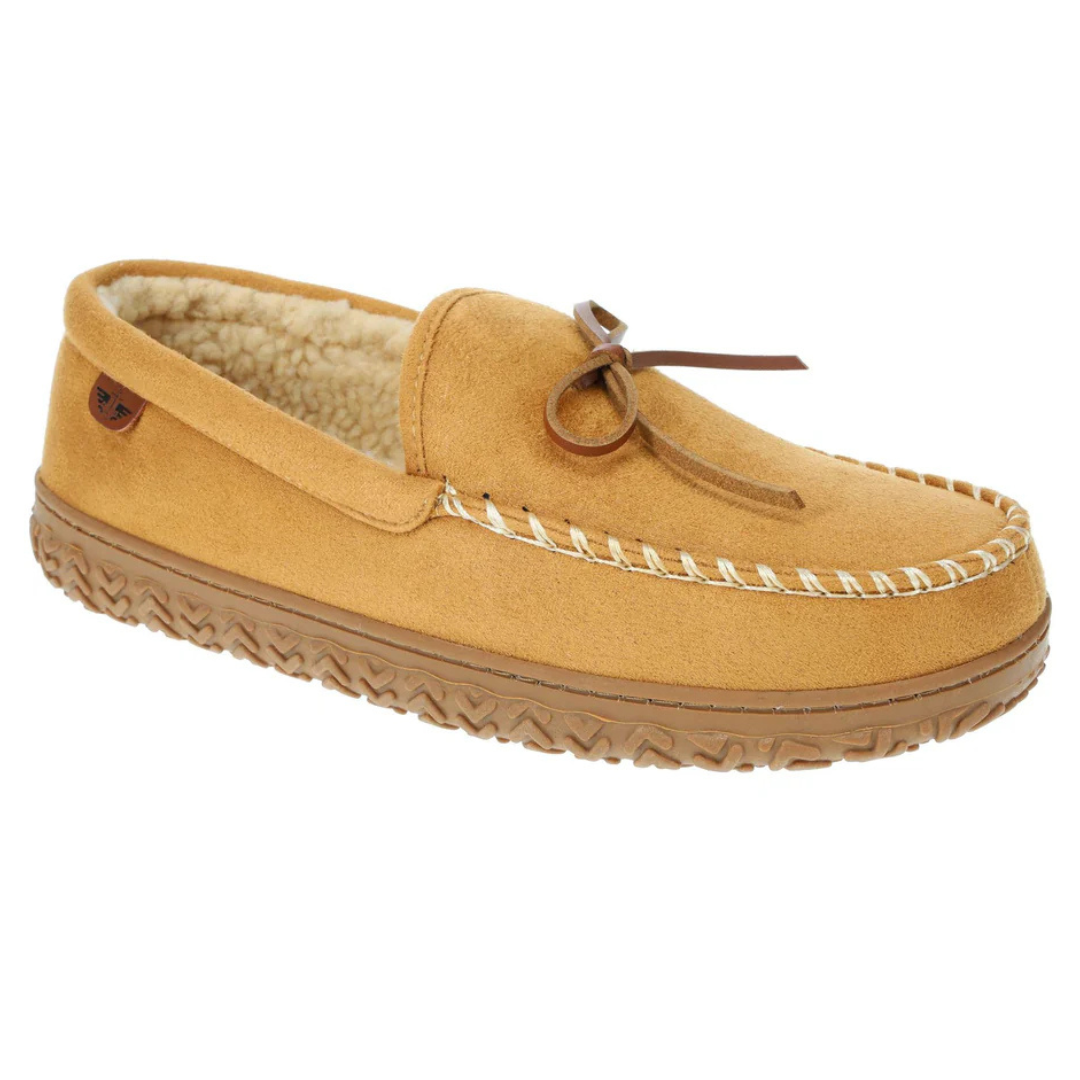 Tan suede moccasin slippers with a soft, fleece-lined interior, decorative leather bow, contrasting white stitching, and a textured rubber sole for grip.