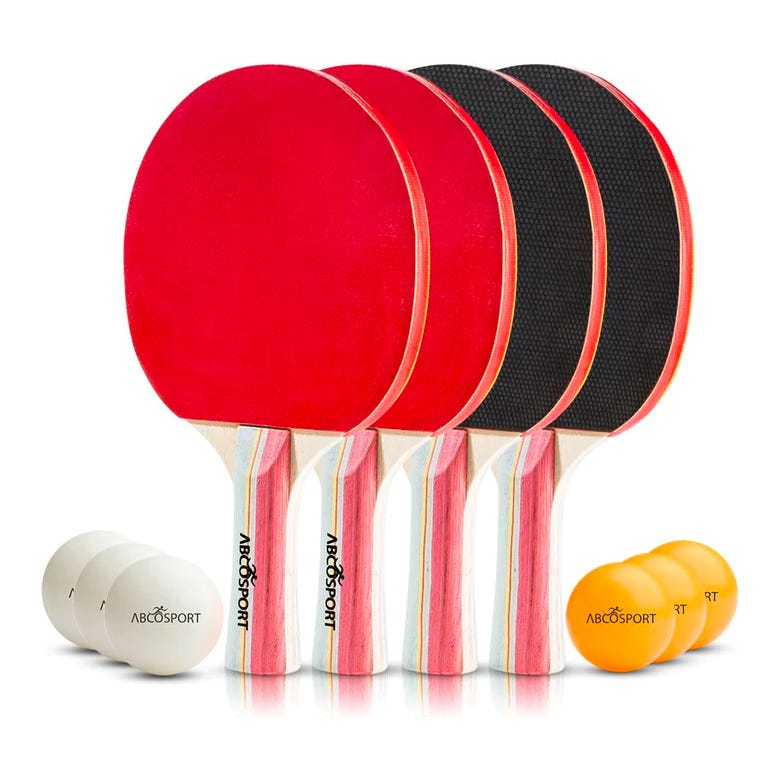 Four ping pong paddles with red and black rubber and three white and orange ping pong balls.