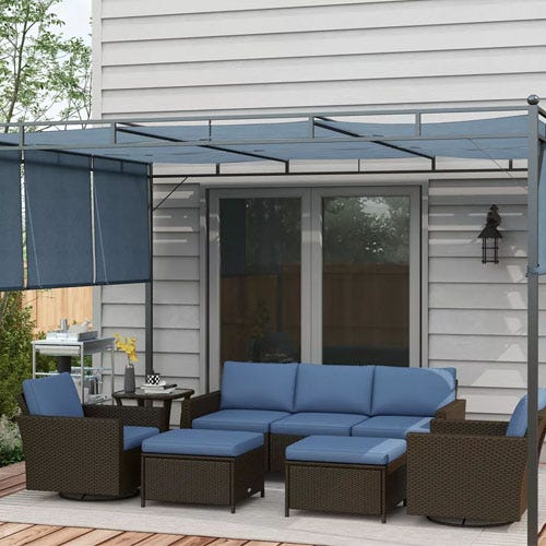 Outdoor patio furniture set with blue cushions under a pergola with retractable canopy.