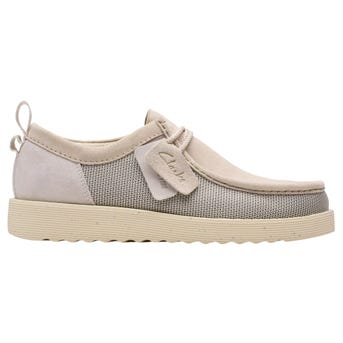 Casual beige shoe with a lace-up design, featuring a textured mesh and suede upper, embossed tag detail, and a flat, ridged sole.