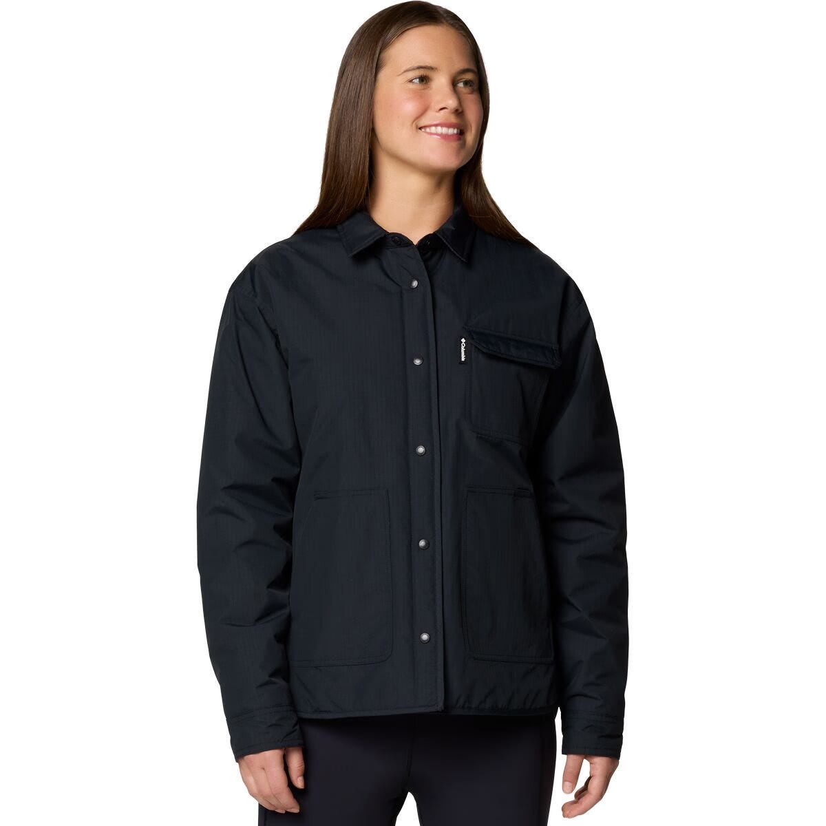 A woman is wearing a dark jacket with front buttons and pockets, including a zippered chest pocket.