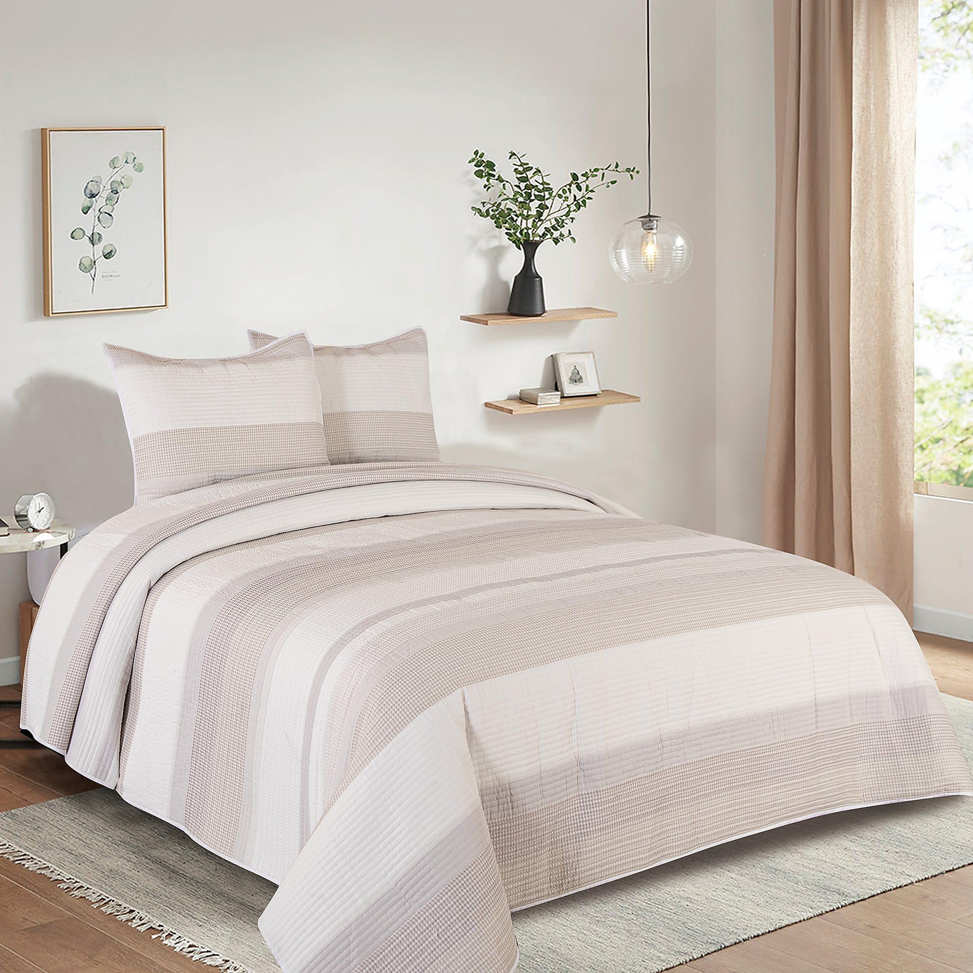 The Waffle Yarn Dyed Stripe Quilt Set features a subtle striped pattern in neutral tones, includes a quilt and two matching pillow shams, and is styled with a modern, minimalist aesthetic.