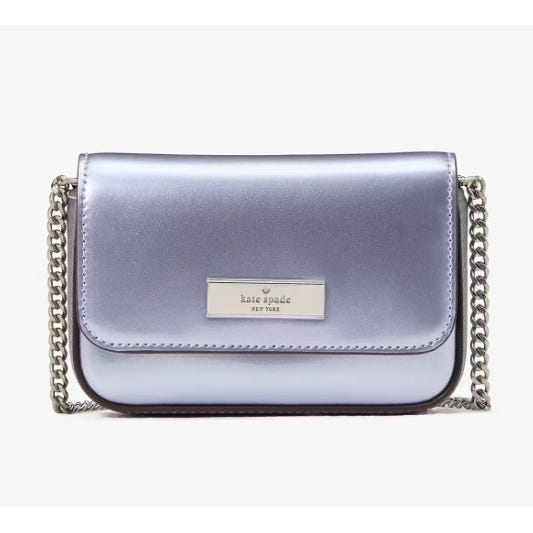 A small metallic lavender shoulder bag with a chain strap and a front logo plate from Kate Spade New York.