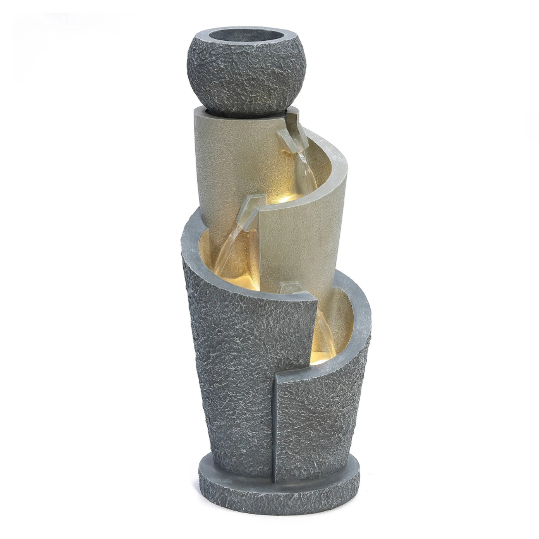 Tall, textured stone-look fountain with cascading water flows between curved tiers, featuring built-in lights and an upper bowl design.