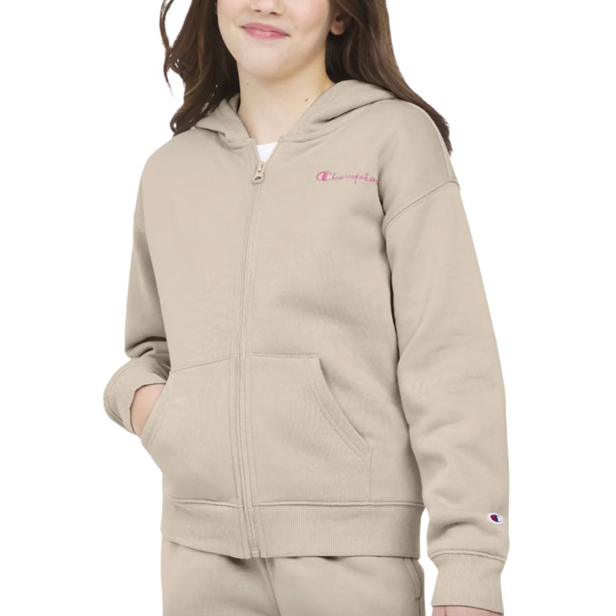 The Champion Girls' Full-Zip Hoodie is a beige zip-up sweatshirt with a hood, featuring the Champion logo on the chest and sleeve. It includes front pockets and ribbed cuffs.
