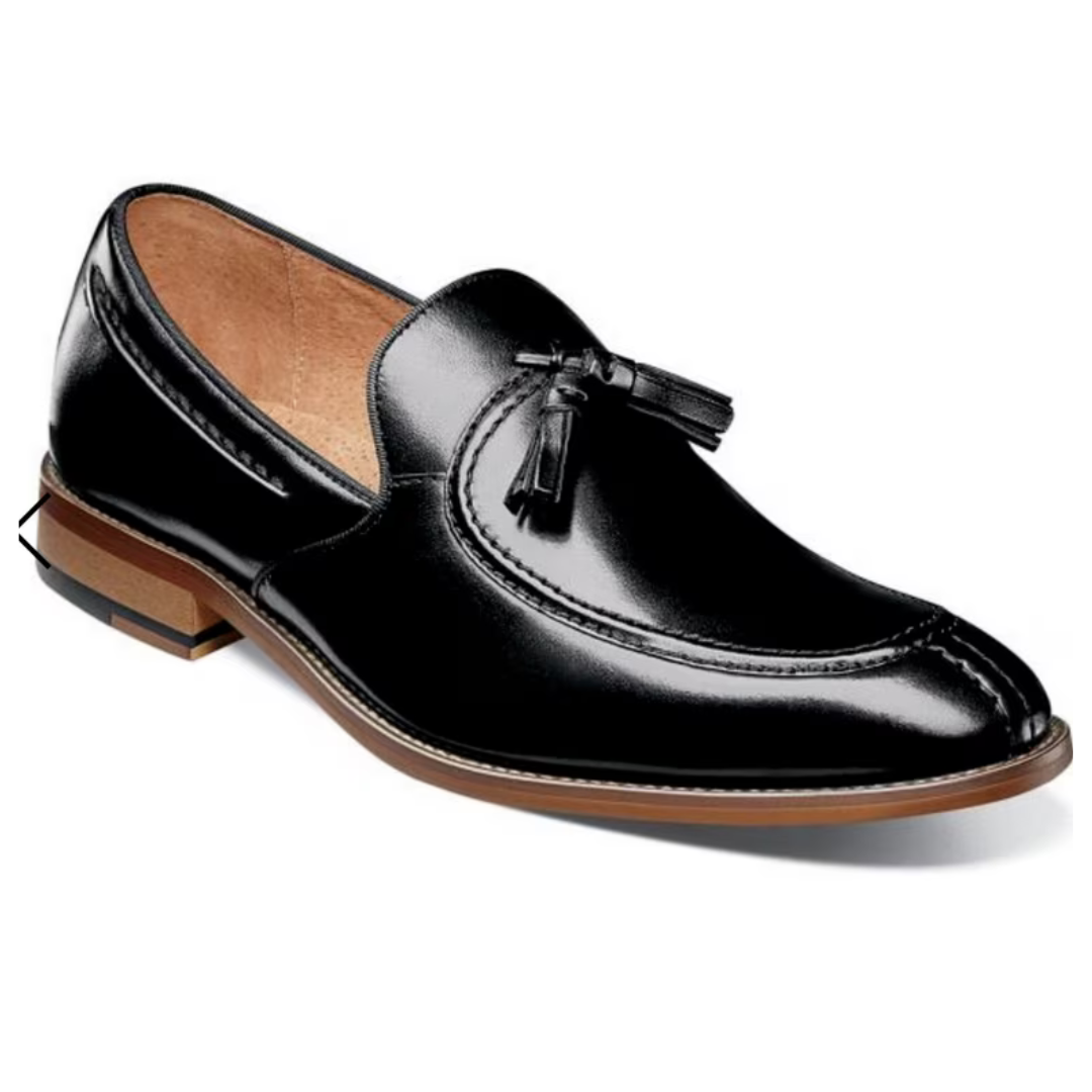 A black leather tassel loafer with brown sole and stitching details, featuring a polished finish and casual elegance.