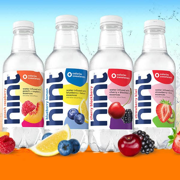 Four bottles of Hint flavored water, labeled with different fruits: peach, blueberry, cherry, and strawberry.