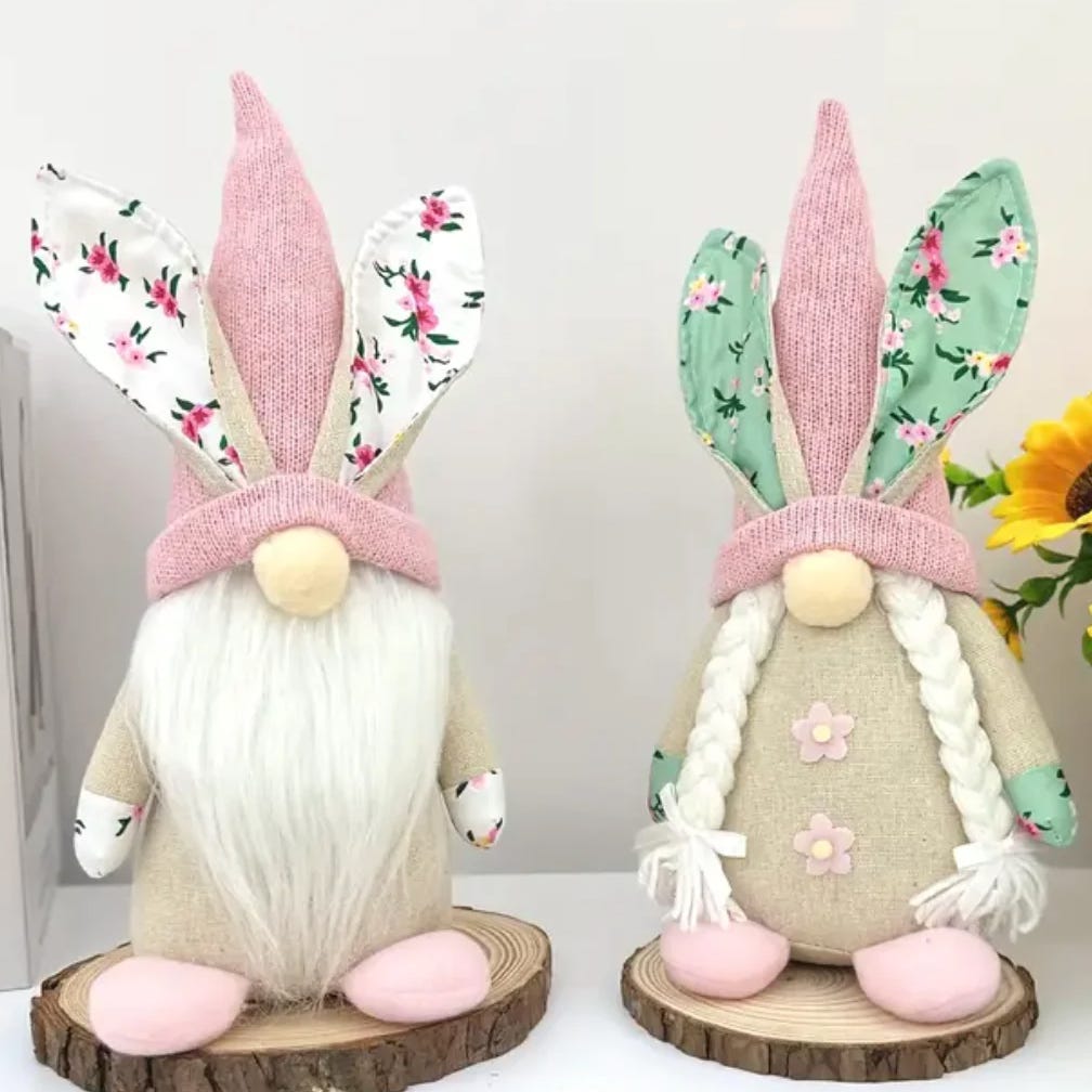 Two decorative gnome figures with bunny ears and braided beards, one in pink and one in green.