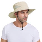 A man is wearing a beige sun hat with a wide brim, UPF 50 protection, mesh side panels for ventilation, and a black adjustable chin strap.