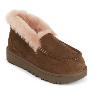 A brown suede moccasin-style shoe lined with pink shearling and featuring a chunky sole, designed for comfort and warmth.