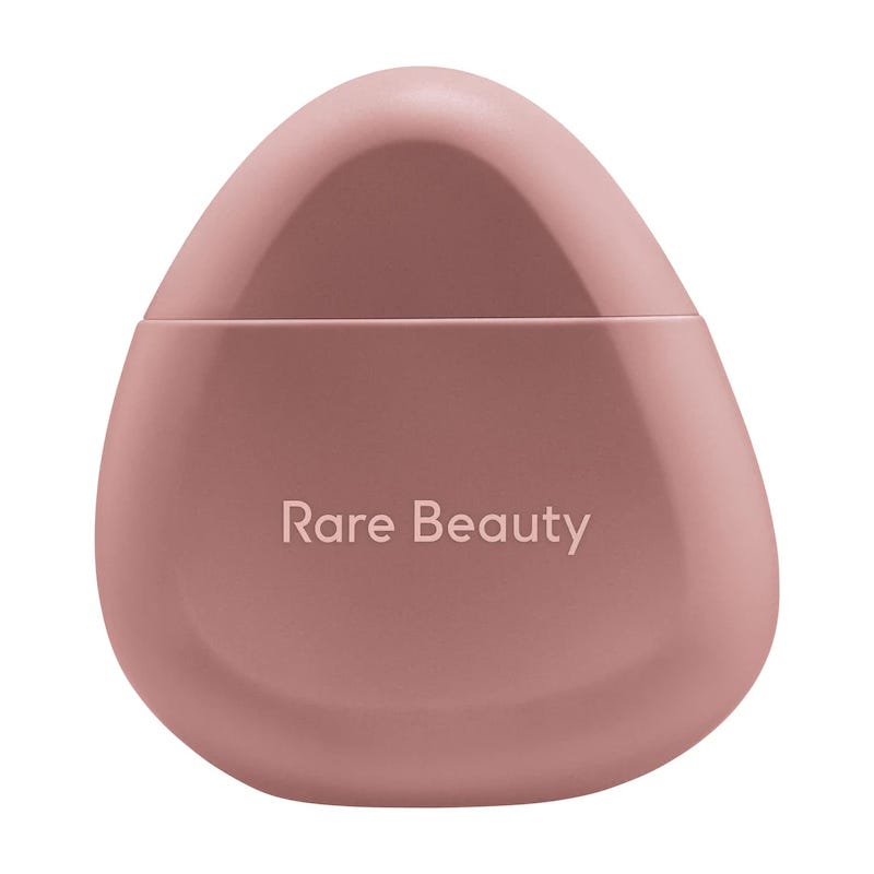 A pink egg-shaped container with the logo \“Rare Beauty\“ on it.