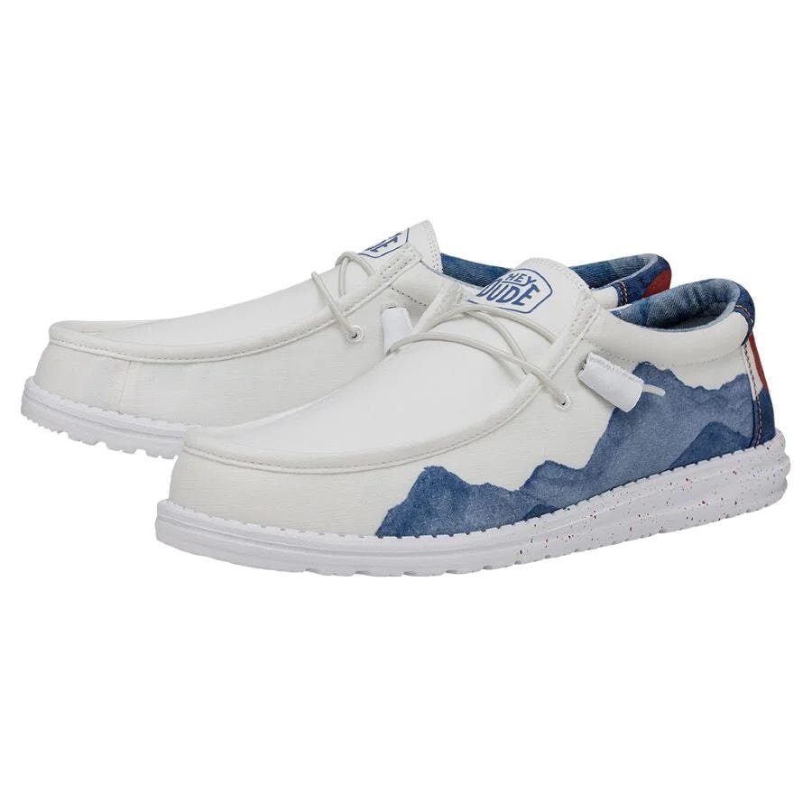 Hey Dude Men's Colorado Watercolor Shoes feature a white upper with blue watercolor wave accents, cushioned soles, and a casual slip-on design with elastic laces for comfort and ease.