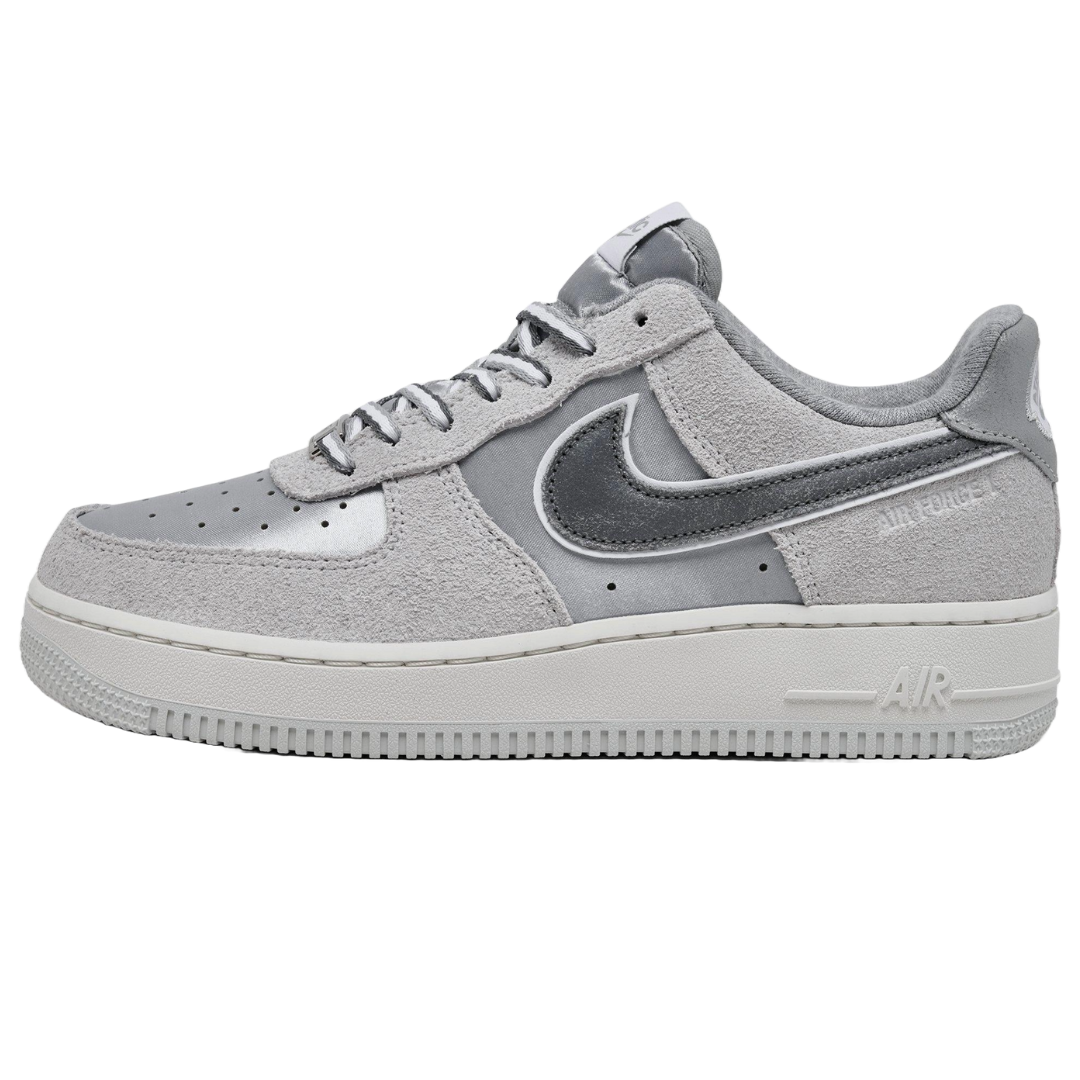 A gray and white Nike Air Force 1 sneaker with a mix of suede and smooth materials, featuring the iconic swoosh logo and \“AIR\“ on the sole.