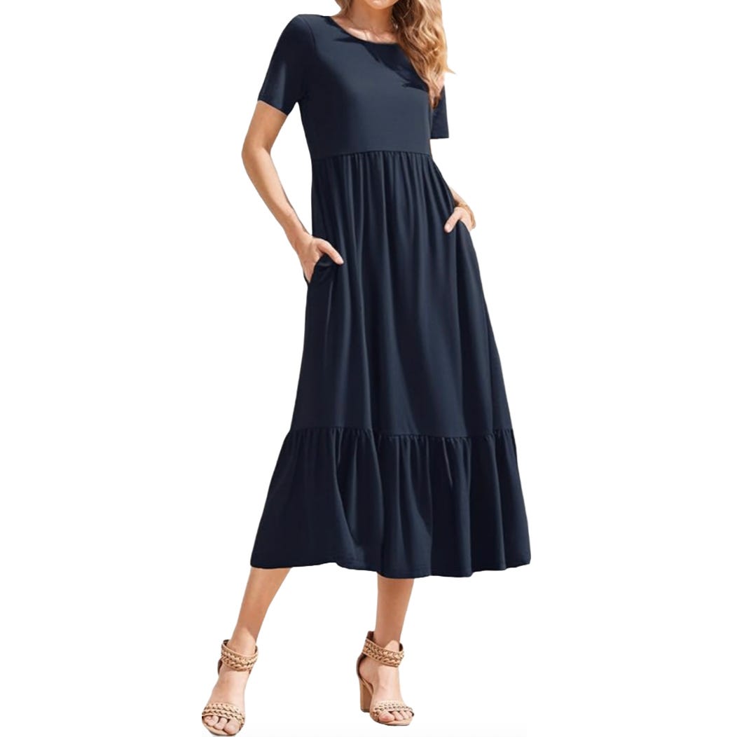 Navy blue, short-sleeve midi dress with a round neckline and tiered skirt. The dress features pockets and is paired with strappy tan heels.