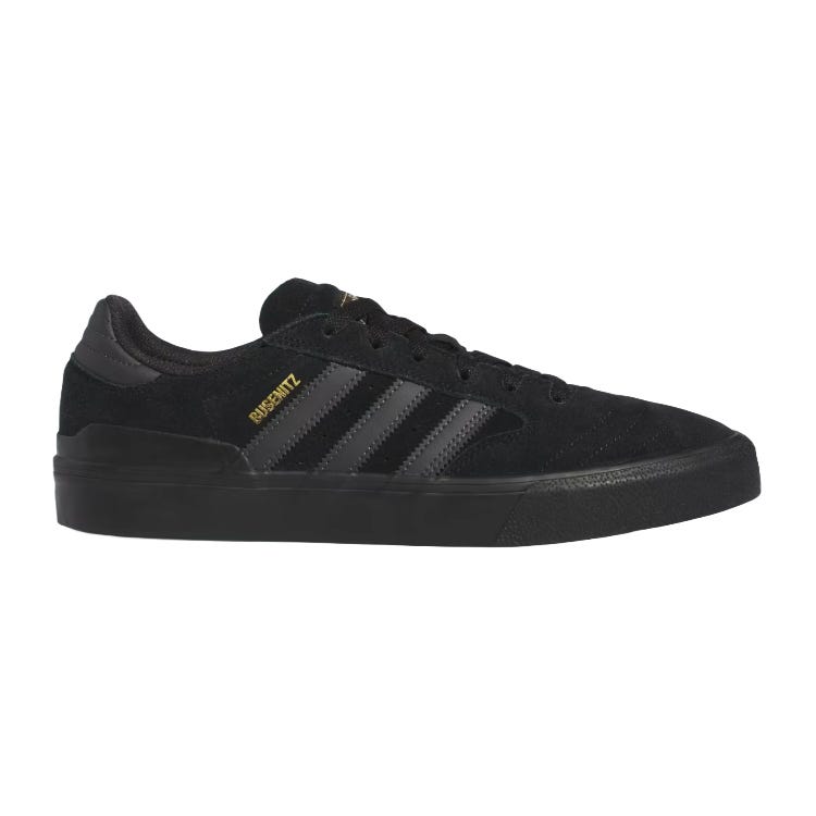 A black Adidas skate shoe with a suede upper, featuring the iconic three stripes and \“BUSENITZ\“ text in gold.