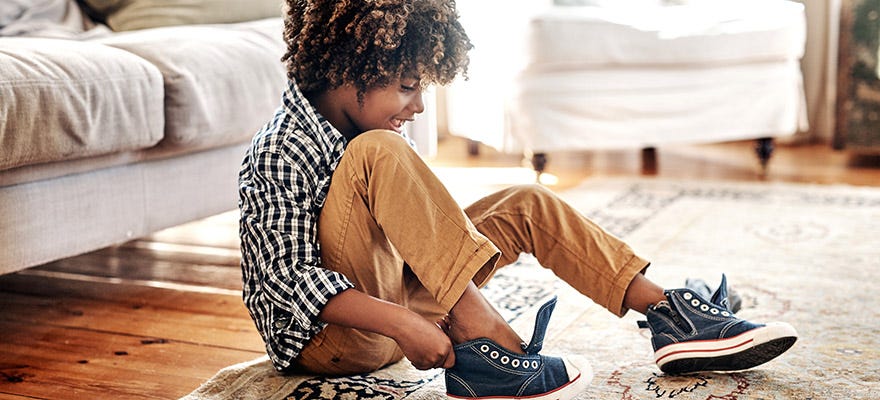 young boy putting on shoes
