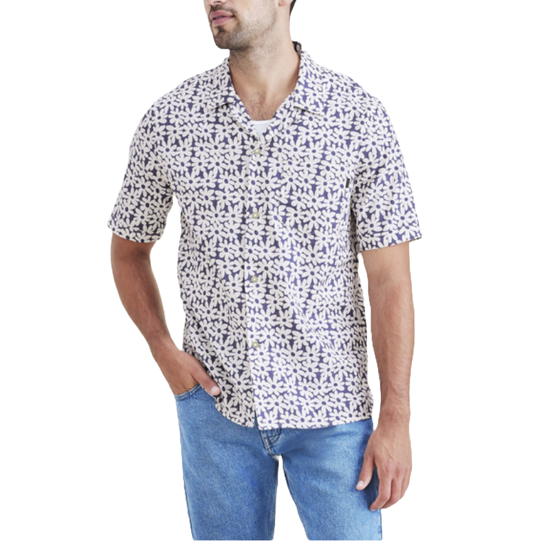 A man is wearing a short-sleeve button-up shirt with a blue and white abstract pattern, paired with light blue jeans.