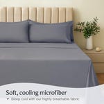 Gray six-piece queen sheet set made of soft, cooling microfiber material, displayed on a bed with a matching pillowcase.