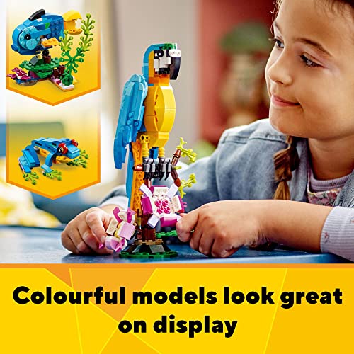 A young child engages with a colorful LEGO set, showcasing pieces assembled into a vibrant parrot perched on a stand, with two other animal options highlighted in the background.