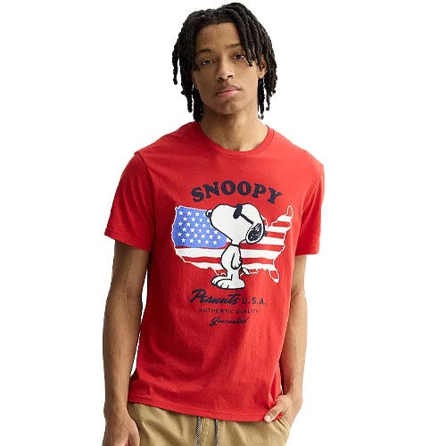 Red T-shirt featuring Snoopy wearing sunglasses, with an American flag design in the background and text that reads \“Snoopy\“ and \“Peanuts U.S.A. Authentic Quality.\“