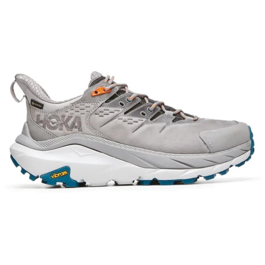 A single gray hiking shoe with orange laces and a Vibram sole.