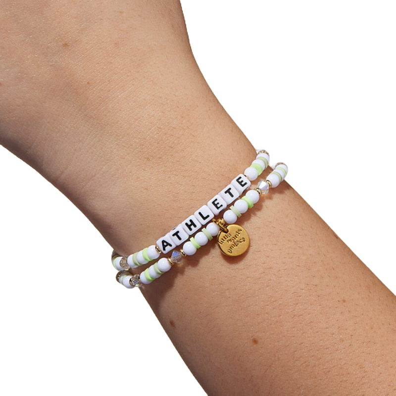 A beaded bracelet with the word \“ATHLETE\“ in black letters on white beads, featuring alternating white and lime green beads, and a gold charm engraved with \“Little Words Project.\“