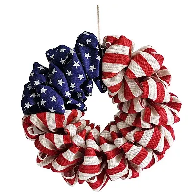 A wreath crafted with ribbon loops patterned in American flag colors: red and white stripes and blue with white stars, arranged in a circular shape.