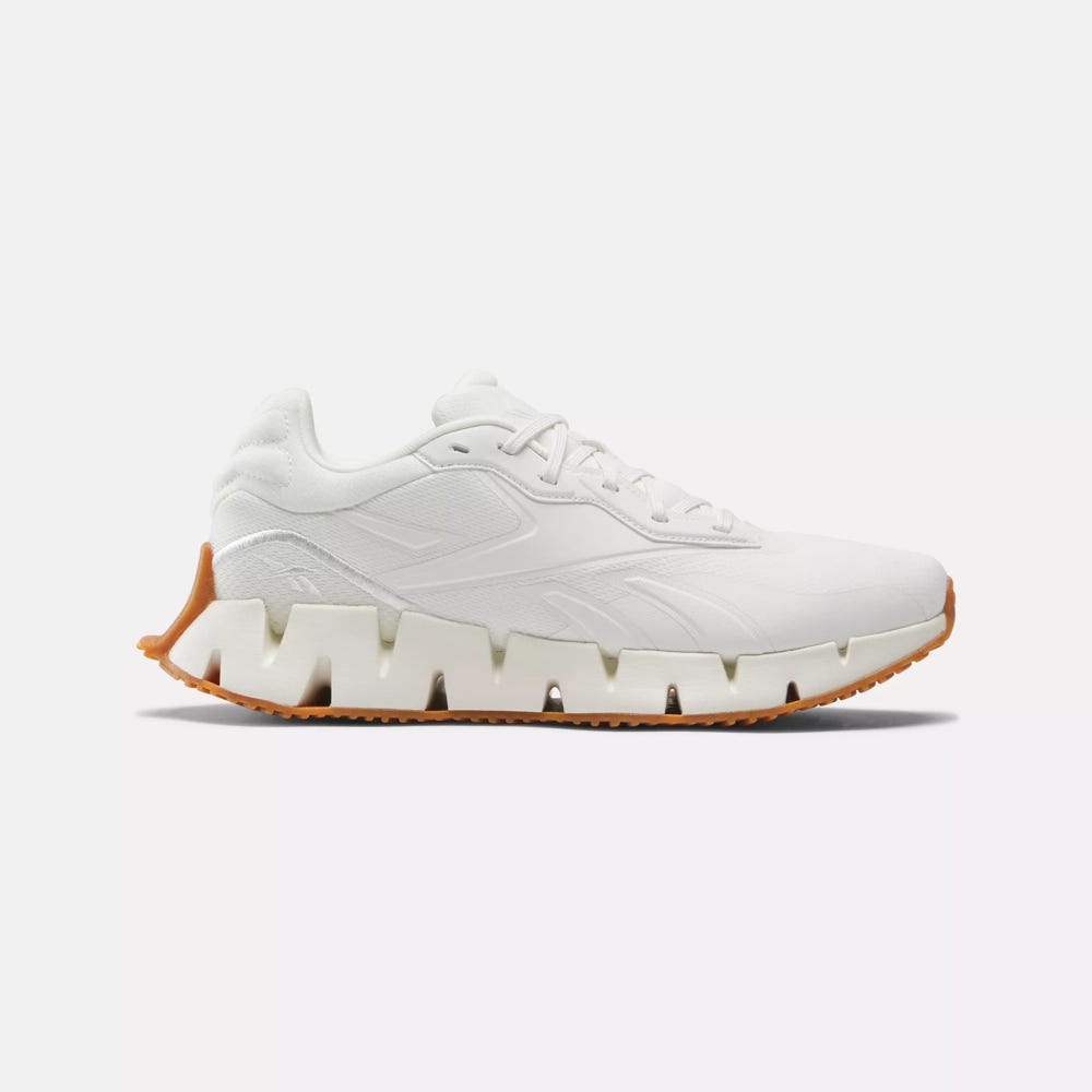 White sneaker with chunky sole and contrasting gum outsole.