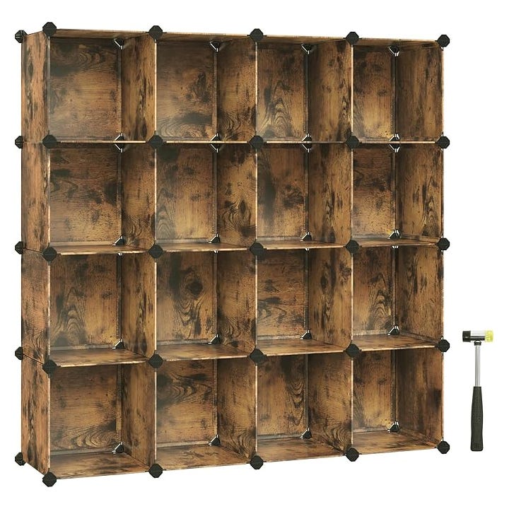 A modular storage organizer composed of 16 cube-shaped compartments with a rustic wood finish, connected by black corner connectors. A black-handled rubber mallet is included for assembly.