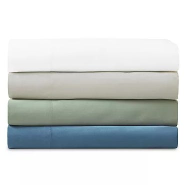 A stack of four folded bed sheets in different colors: white, beige, light green, and blue.