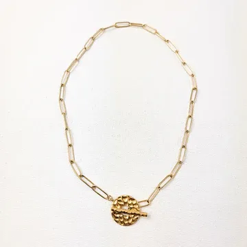 Gold chain necklace with a textured pendant.