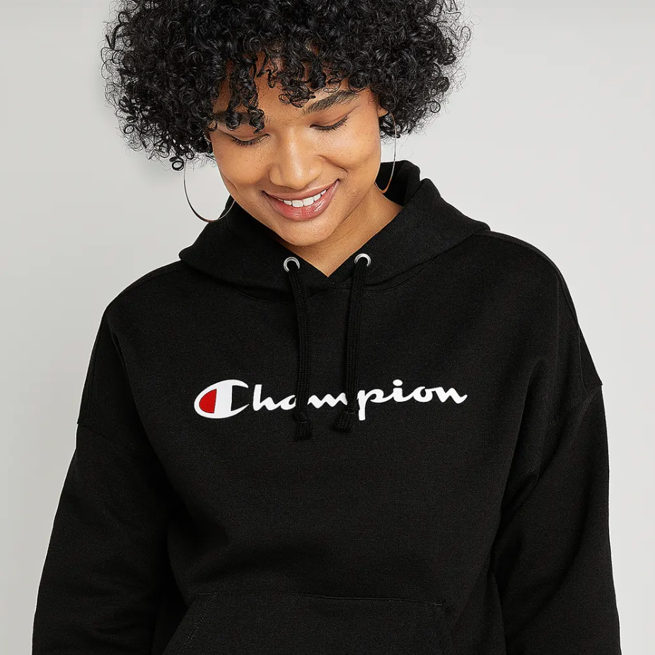 A person wearing a black hoodie with a white and red logo on the front.