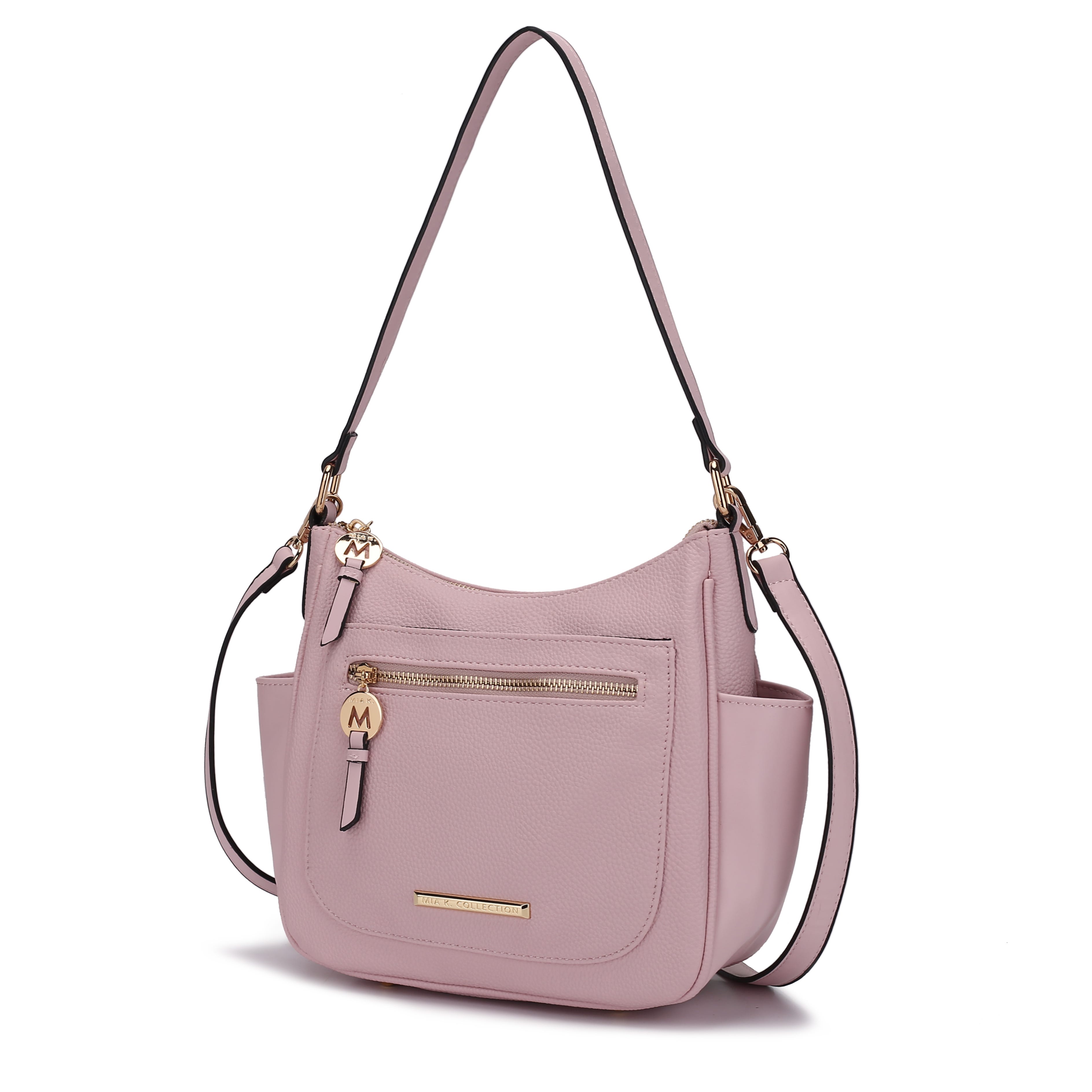 A light pink shoulder bag with gold-tone hardware, featuring a front zip pocket with a \“M\“ charm and an adjustable strap.