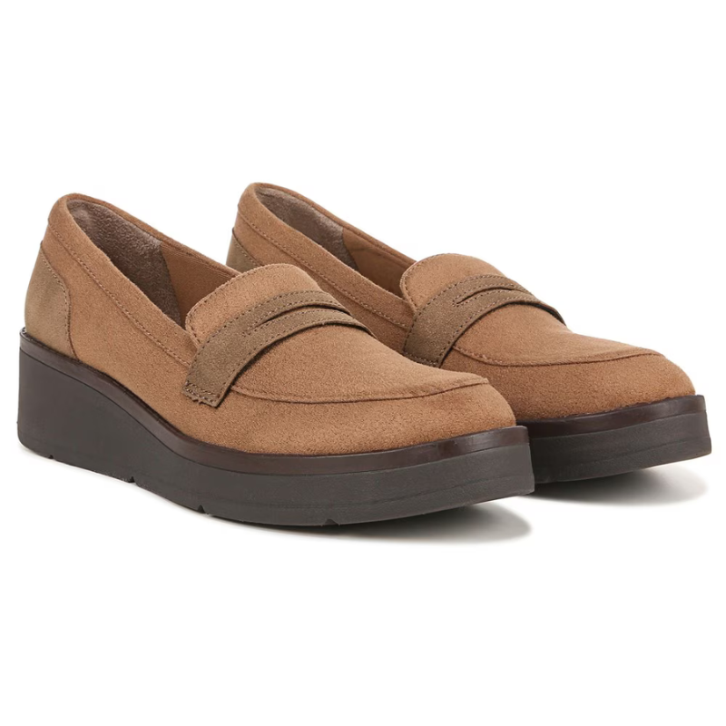 A pair of tan suede loafers with a thick black sole and a strap detail across the vamp.