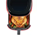A PowerXL Vortex Air Fryer with an open drawer displaying a whole roasted chicken surrounded by vegetables.