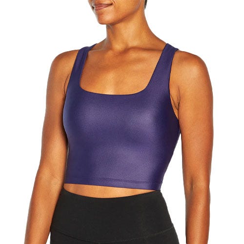 A purple Lina Sports Bra is shown, featuring a sleeveless design with a square neckline and a cropped fit, paired with black leggings.