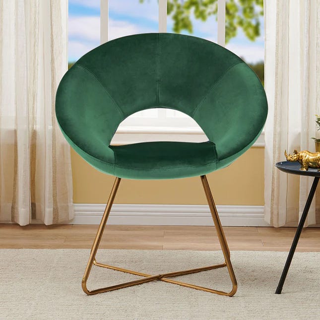 Emerald green velvet accent chair with a circular backrest and gold-finish metal legs.