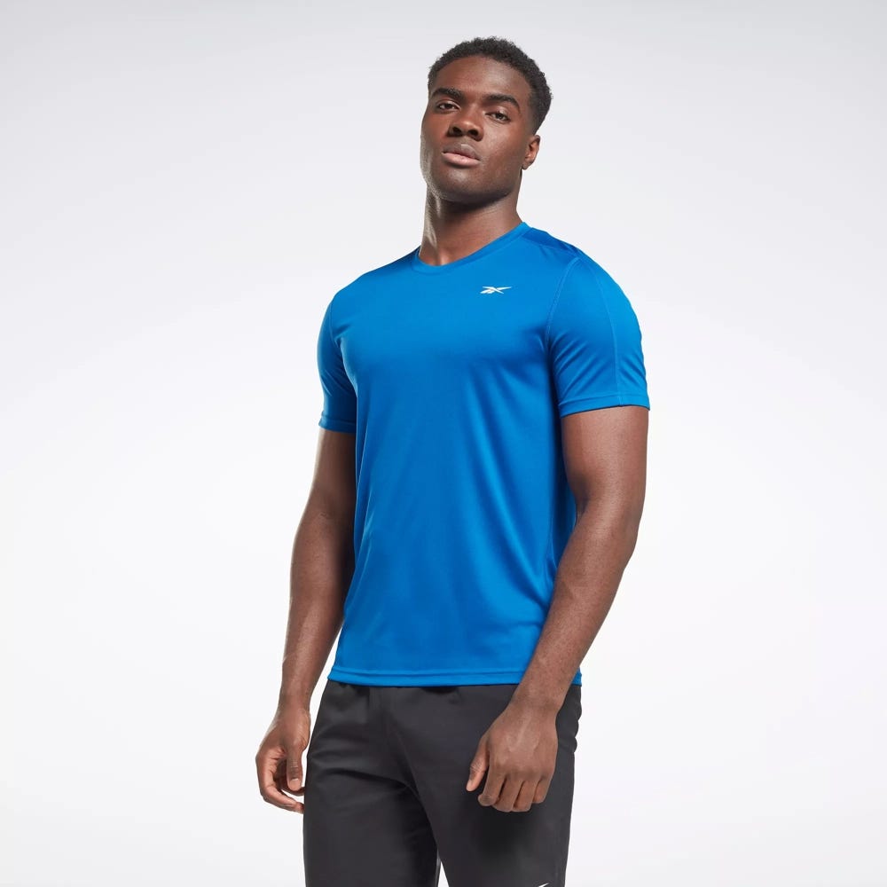 A man wearing a blue crew neck athletic T-shirt and black sports shorts.