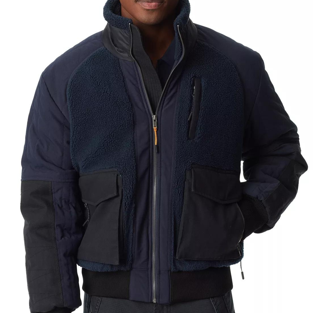 A man wearing a navy blue and black fleece jacket with zippered pockets.