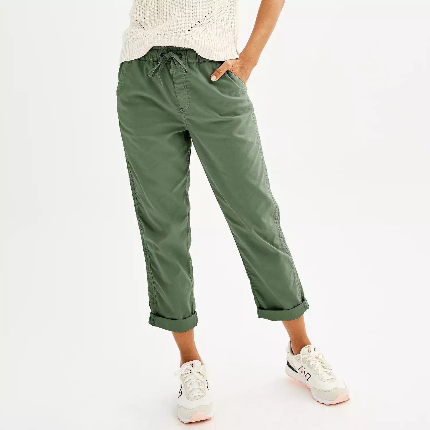 Olive green, cropped jogger pants with drawstring waist, paired with white sneakers.